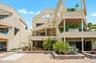 Back of townhome with parking space and covered porch