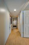 A well-lit central hallway connects the main living areas with the bedrooms, showcasing consistent tile flooring and a clean, streamlined flow through