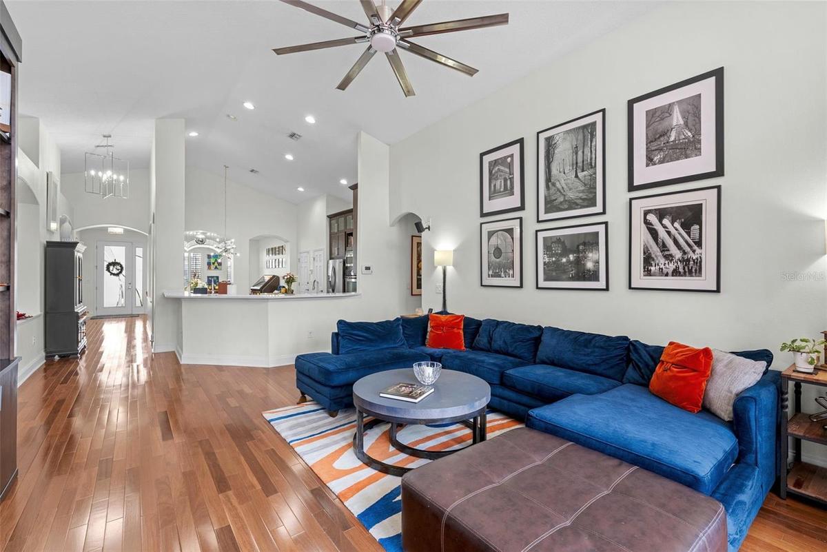 Open-concept living area with beautiful wood flooring and high ceilings.