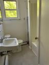 Bathroom with toilet, a baseboard heating unit, and sink