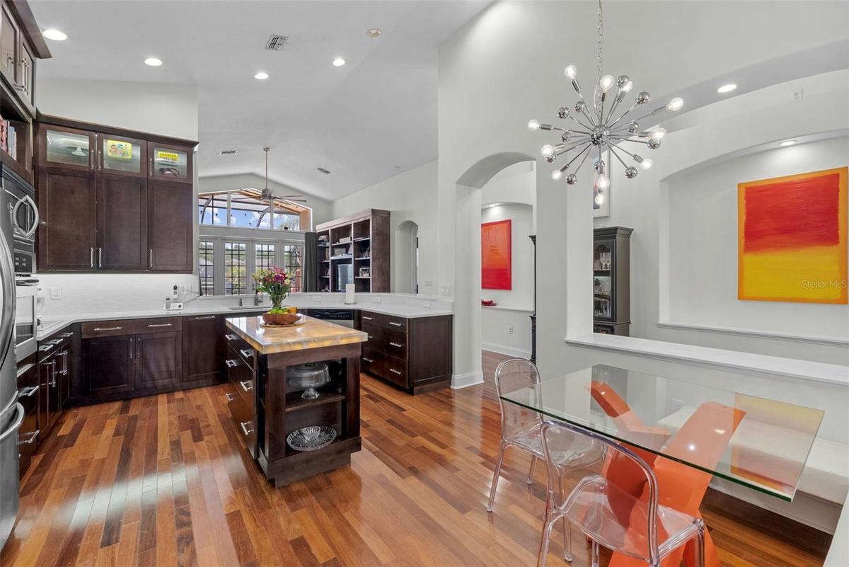 Custom kitchen with center island, rich cabinetry, and modern lighting.