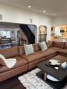 Living room featuring wood finished floors, plenty of natural light, recessed lighting, arched walkways, and stairs