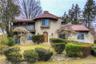 Mediterranean / spanish home featuring a balcony, stucco siding, a chimney, and a tile roof