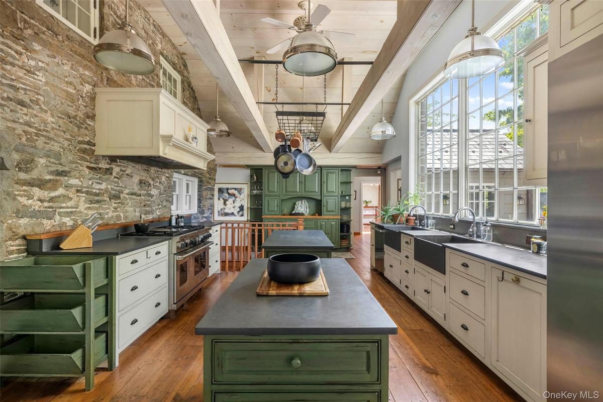 Soaring ceilings and oversized windows with views over the gardens fill the kitchen with natural light
