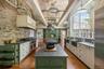 Soaring ceilings and oversized windows with views over the gardens fill the kitchen with natural light