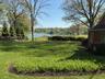 Expansive green lawn with established trees and waterfront access