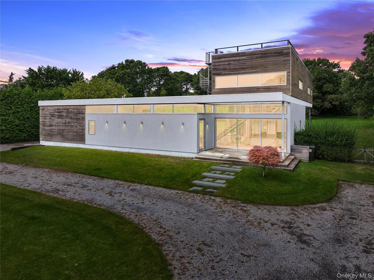 Back of property with a lawn