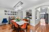 Bright dining room with modern chandelier and warm wood flooring.