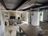 Dining space featuring a stone fireplace and a wood ceiling with exposed beams