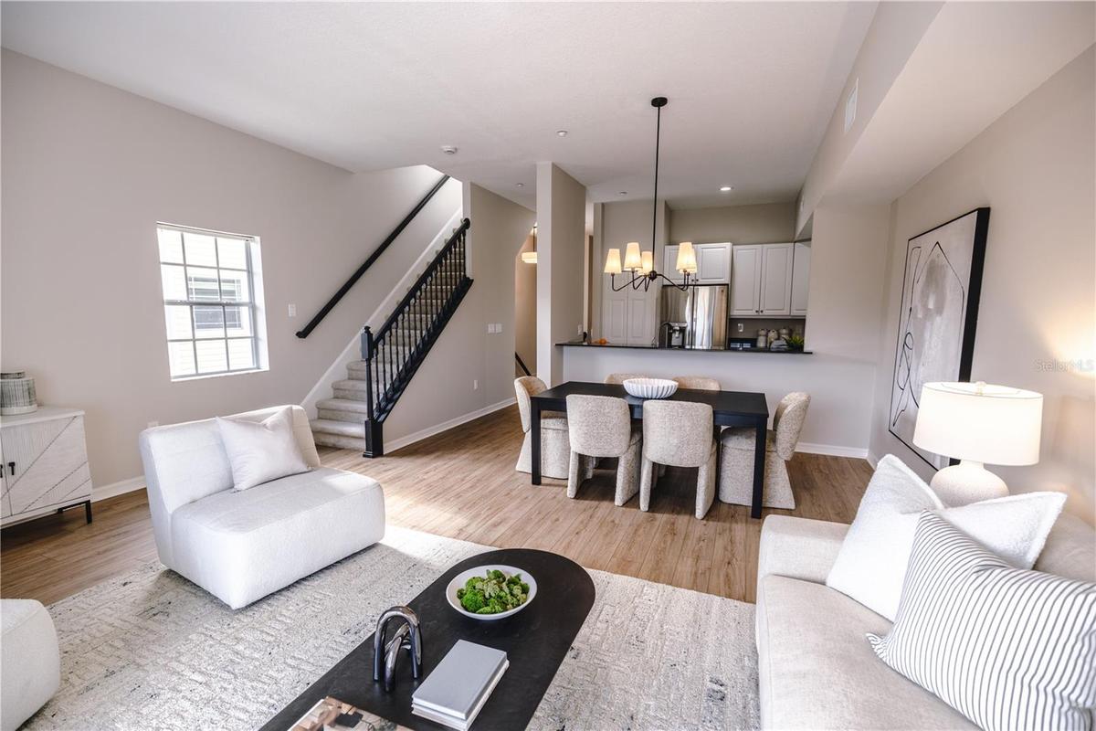 Open concept living and dining room with natural light and balcony overlooking mangroves.