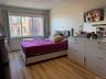 Bedroom featuring a fireplace, light wood-type flooring, and baseboard heating