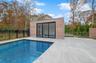 View of swimming pool featuring an outbuilding, a patio area, and a storage structure
