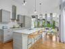 Kitchen featuring healthy amount of natural light, light wood-style flooring, modern cabinets, recessed lighting, and expansive windows