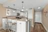 Kitchen wall taken out; replaced with marble counter top; breakfast bar.