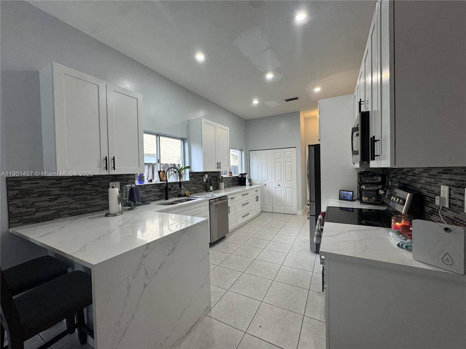 Beautifully updated and well maintained home with volume ceilings, and modern finishes feauturing a custom kitchen with quartz countertops, stainless appliances, and white shaker cabinetry providing plenty of storage.
