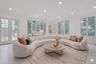 Two walls of windows frame stunning views of the saltwater pool, lush level lawn, and beautifully landscaped grounds, bringing the outdoors in through