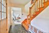 Foyer with a baseboard radiator, dark stone finish flooring, dark carpet, and stairs