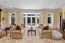 Living area featuring wood finished floors, a wainscoted wall, a decorative wall, crown molding, and a fireplace