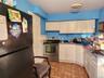 Kitchen with freestanding refrigerator, stainless steel range with electric stovetop, white cabinets, and dark countertops