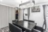 Dining area featuring a contemporary chandelier, wood-finish flooring, two windows, and a built-in closet with slatted panel doors