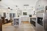 Kitchen with stainless steel appliances, a peninsula, a kitchen bar, open shelves, and glass insert cabinets