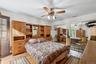 Bedroom with light wood-style flooring, ceiling fan, and multiple closets