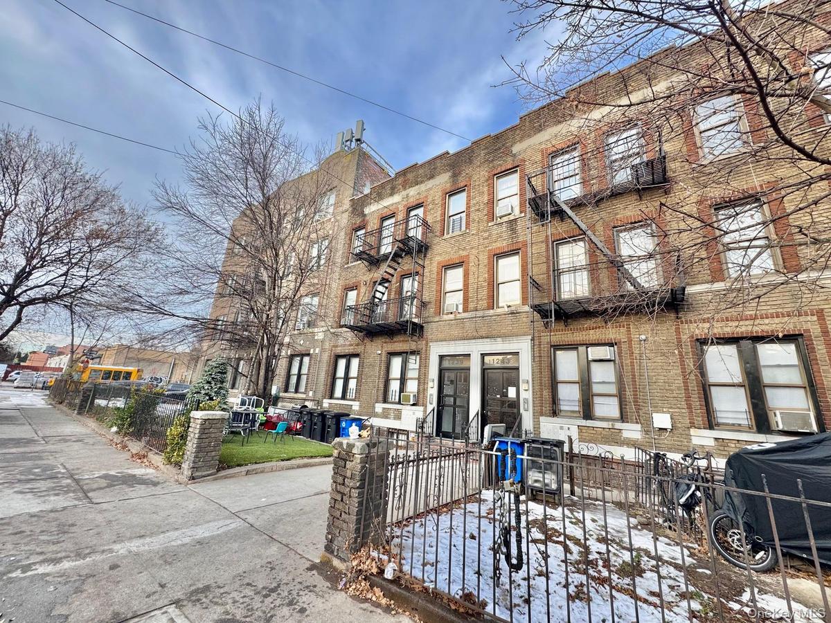 View of apartment building / complex with a fenced front yard
