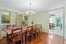 Dining area featuring dark wood-type flooring, crown molding, a chandelier, ceiling fan, and a baseboard heating unit