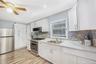 Kitchen with appliances with stainless steel finishes, white cabinetry, decorative backsplash, recessed lighting, and light wood-style flooring