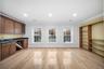 Bar area with crown molding, glass insert cabinets, light wood-type flooring, recessed lighting, and dark stone counters