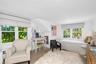 Bright interior featuring light wood-finish flooring, white walls, and multiple windows