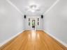 Hardwood flooring with decorative inlay, ceiling fan with light fixture, and crown molding