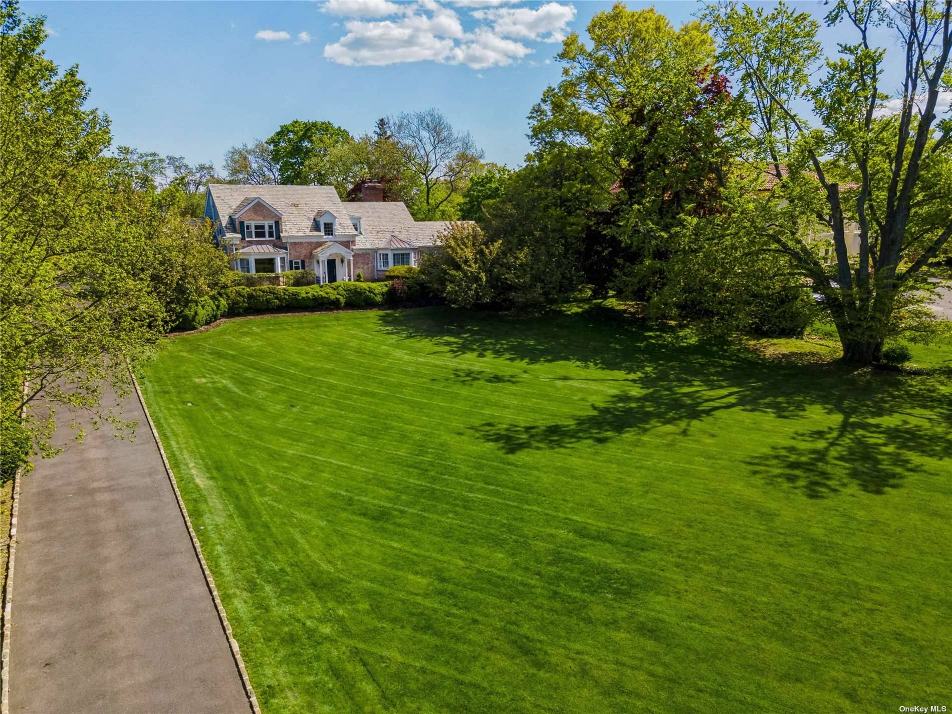Stately brick colonial on an oversized property in the heart of Hewlett Bay Park.