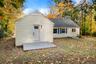 Convenient rear entry leads directly into the home, surrounded by a peaceful wooded backdrop ideal for privacy and relaxation.