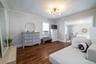 Hardwood-finish flooring dressing room extending into primary bedroom