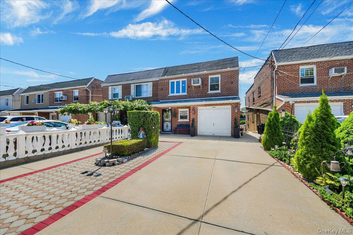Two family brick property with an attached garage & driveway