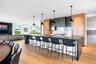 Kitchen with modern cabinets, a breakfast bar, decorative light fixtures, a large island, and light wood finished floors