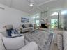 This large family room with soaring ceilings includes a wood burning fireplace