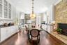 Dining room with ornamental molding, dark wood-style floors, a stone fireplace, and recessed lighting