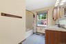 Bathroom featuring a wood-finish vanity with a light-colored countertop and undermount sink, a framed mirror, and built-in medicine cabinets