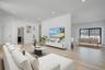 Spacious and open living area filled with natural sunlight from oversized windows, designed for both everyday comfort and entertaining.