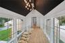 Hallway with light wood finished floors, lofted ceiling, and wooden ceiling