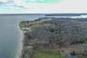 Aerial view of property and surrounding area with a large body of water and a heavily wooded area