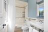 Bathroom featuring shower / bath combo, tile walls, and light tile patterned floors