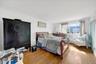 Bright room featuring wood-finish flooring, white walls, and a window providing natural light