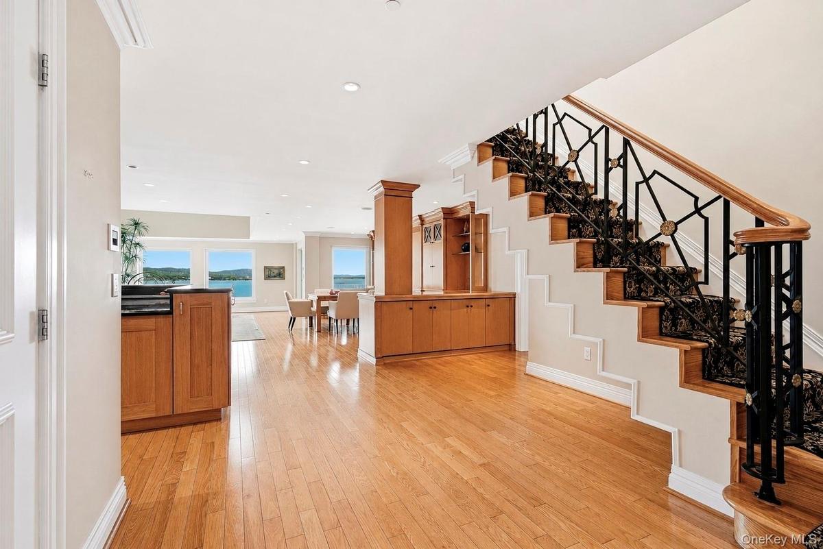 Entry foyer with grand staircase and gleaming hardwood floors.
