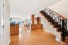 Entry foyer with grand staircase and gleaming hardwood floors.
