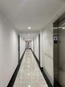 Hall featuring elevator, light marble finish flooring, inlaid floor details, and recessed lighting