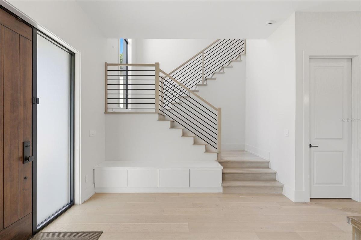 Clean lines of the modern stairway and storage closet to the right