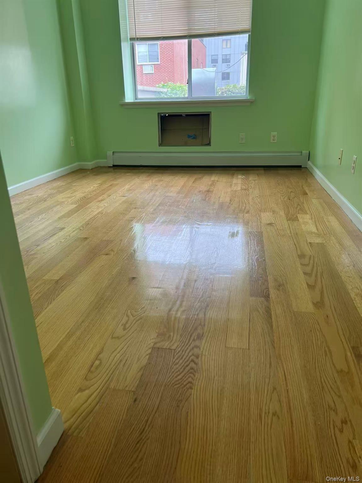 Empty room with baseboards and a baseboard radiator